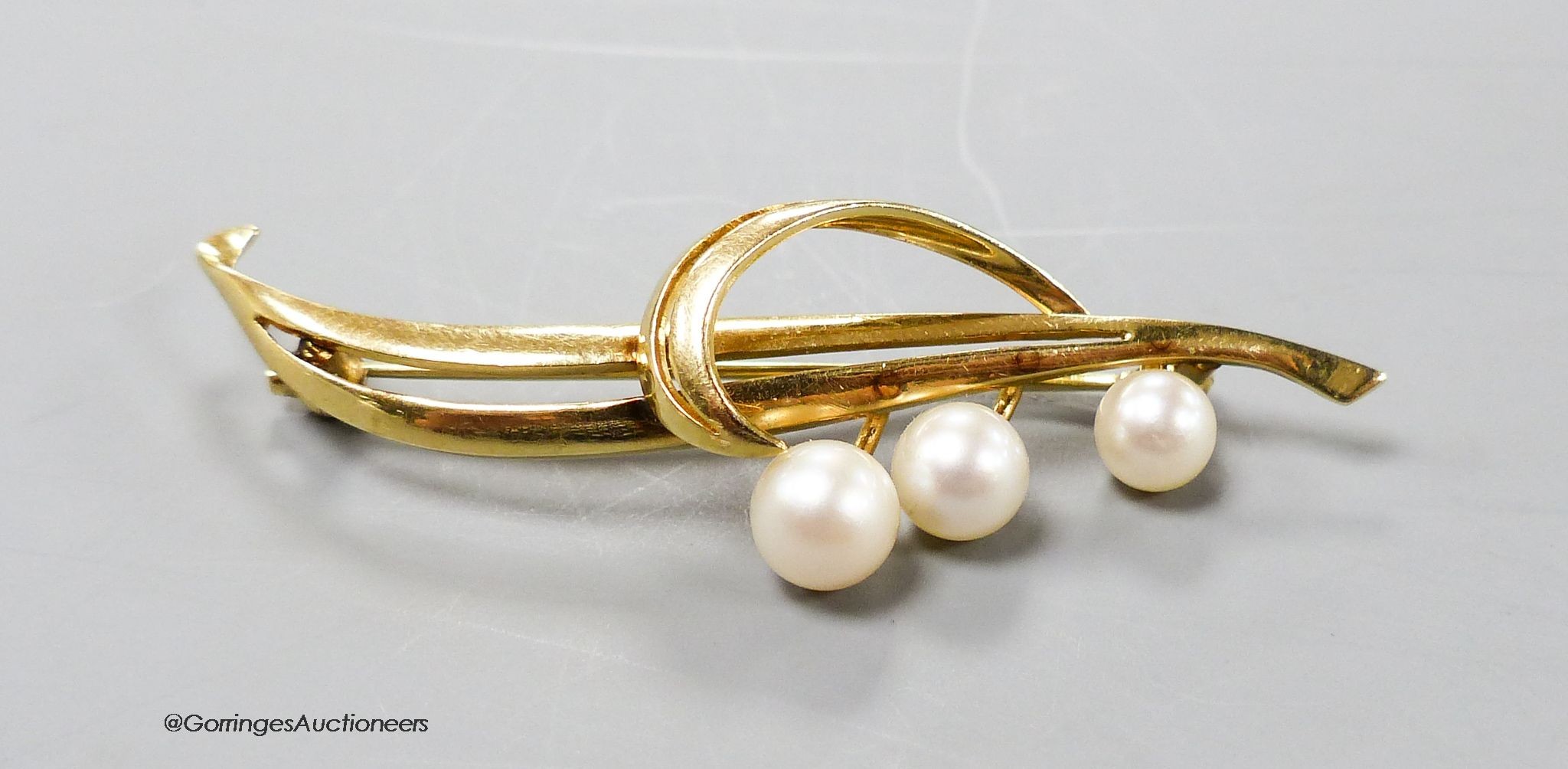 A yellow metal (stamped 14k) and three stone cultured pearl set spray brooch, 55mm, gross 5.2 grams.